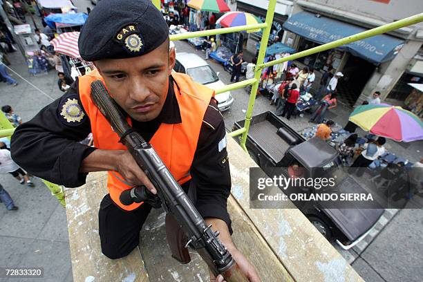 Un agente de la Policia Nacional Civil vigila una avenida comercial en Ciudad de Guatemala, el 15 de diciembre de 2006. Con el objetivo de garantizar...