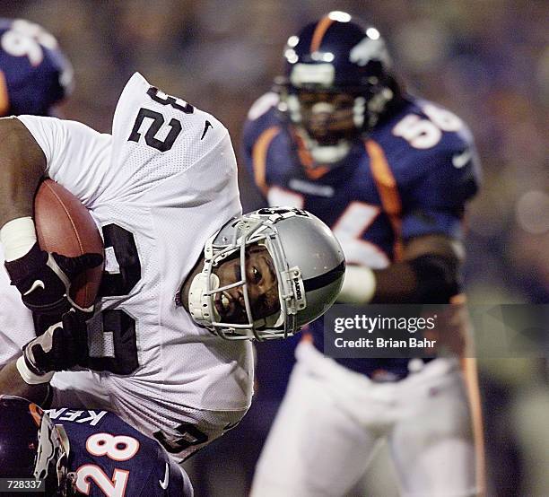 Running back Zack Crockett of the Oakland Raiders goes horizontal as safety Kenoy Kennedy of the Denver Broncos hits him and keeps him out of the...