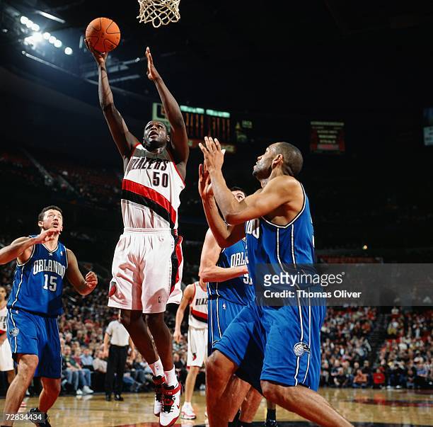 Zach Randolph of the Portland Trail Blazers takes the ball to the basket against Hedo Turkoglu and Grant Hill of the Orlando Magic at The Rose Garden...