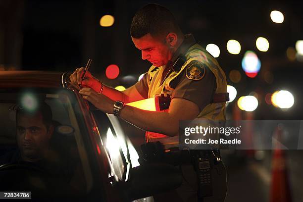 Trooper David Casillas, from the Florida Highway Patrol, talks to a driver at a DUI checkpoint December 15, 2006 in Miami, Florida. The city of...