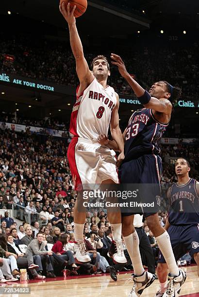 Jose Calderon of the Toronto Raptors goes to the basket against Mikki Moore of the New Jersey Nets at Air Canada Centre on December 15, 2006 in...