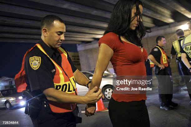 Officer Kevin Millan from the City of Miami Beach police department arrests a woman after she failed a field sobriety test at a DUI checkpoint...
