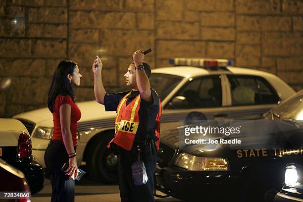 Officer Kevin Millan from the City of Miami Beach police department conducts a field sobriety test at a DUI traffic checkpoint December 15, 2006 in...