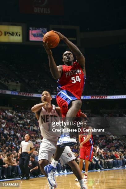 Jason Maxiell of the Detroit Pistons shoots against Marcus Williams of the New Jersey Nets on December 16, 2006 at the Continental Airlines Arena in...