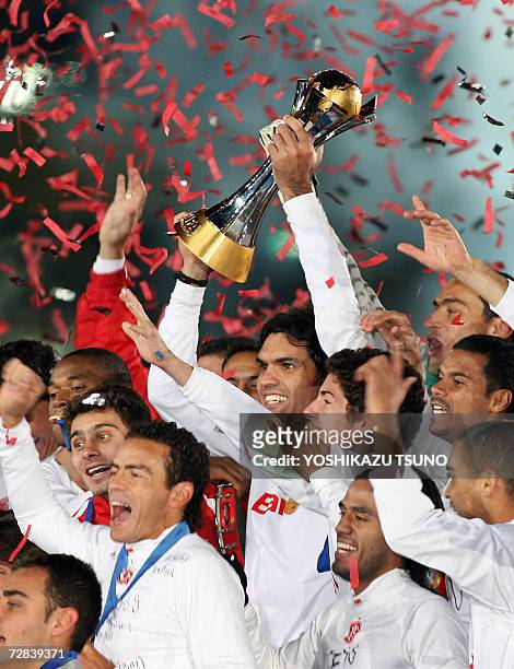 Brazil's Internacional forward Fernandao holds the trophy as team members celebrate during the awards ceremony of the FIFA Club World Cup in...