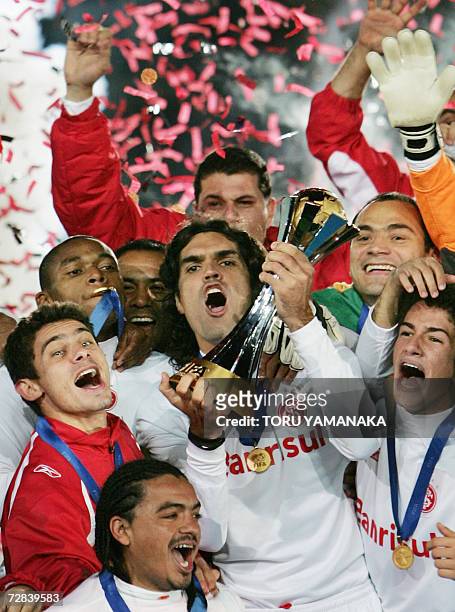 Brazil's SC Internacional captain Fernandao holds up the winner's trophy as he shares the joy with his teammates during the awards ceremony after...
