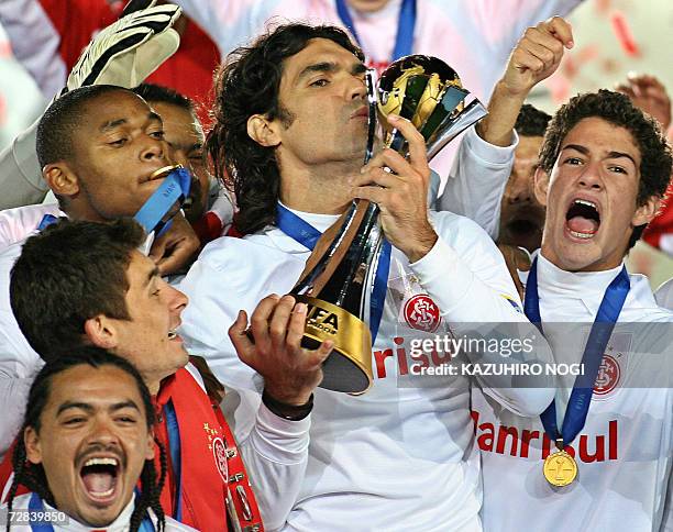 Brazil's SC Internacional captain Fernandao kisses the winner's trophy as he shares the joy with his teammates during the awards ceremony after their...