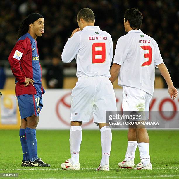 Spain's FC Barcelona forward Ronaldinho of Brazil puts out his tongue after missing a free kick as he stands beside Brazil's SC Internacional...
