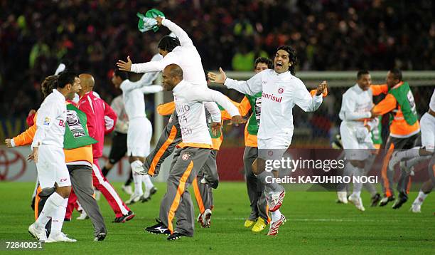 Brazil's SC Internacional players and team staff celebrate their victory over Spain's FC Barcelona after the final of the FIFA Club World Cup in...