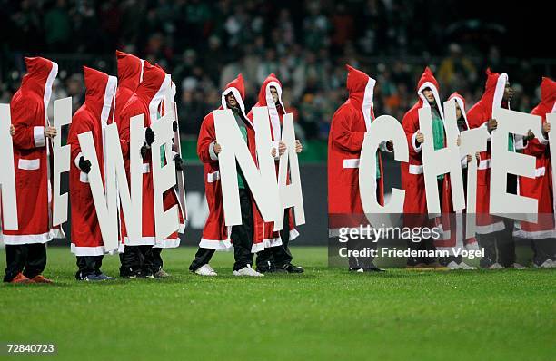 Werder players wear Santa Claus coats as they wish a merry Christmas to their fans after the Bundesliga match between Werder Bremen and VFL Wolfsburg...