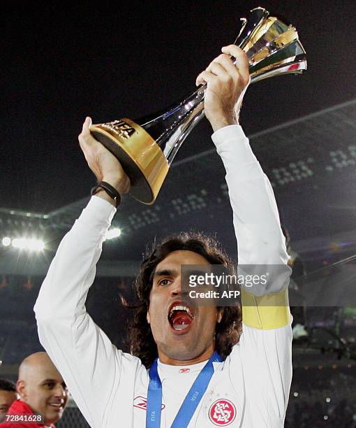 Brazil's SC Internacional captain Fernandao holds the champion trophy after their final match against FC Barcelona for the FIFA Club World Cup Japan...