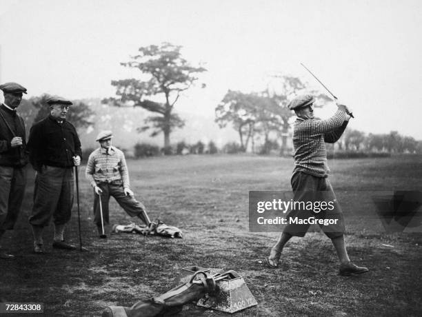 Arsenal defender Tom Parker takes a swing during a team training day at a golf course in Hatch End, 14th November 1929. Team mate David Jack, manager...