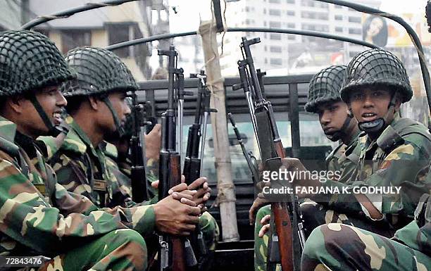 Bangladeshi army soldiers look out from the rear of a van on patrol through the streets of Dhaka, 13 December 2006. Bangladesh's Chief Advisor of...