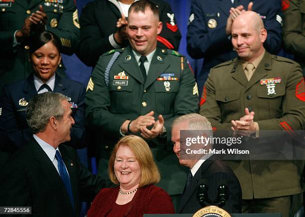 Robert Gates smiles while he stands with his wife Becky and US President George W. Bush after being sworn in as Defense Secretary during a ceremony...