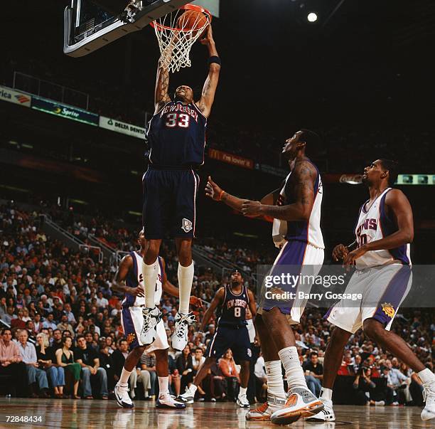 Mikki Moore of the New Jersey Nets takes the ball to the basket against Amare Stoudemire and of the Phoenix Suns during a game at US Airways Center...