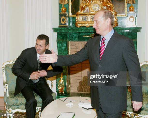 Moscow, UNITED STATES: Russian President Vladimir Putin greets the Syrian delegation as Syrian President Bashar al-Assad takes a seat as they meet at...