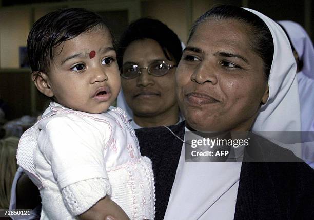 Indian Christian Nun Kokila poses with Asha Bharati at The Matruchhaya Orphanage in Nadiad, some 60kms south of Ahmedabad, 19 December 2006, during a...