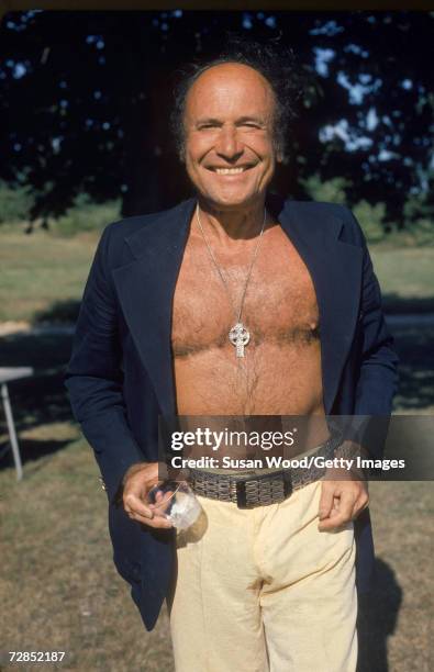 American landowner Robert David Lion Gardiner smiles with glass in hand and a medallion on his chest in a shirtless portrait on his private island,...