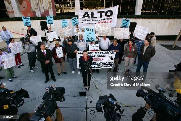 Latino activists speak to the media to protest recent immigration raids across the country at a demonstration and news conference in front of the...
