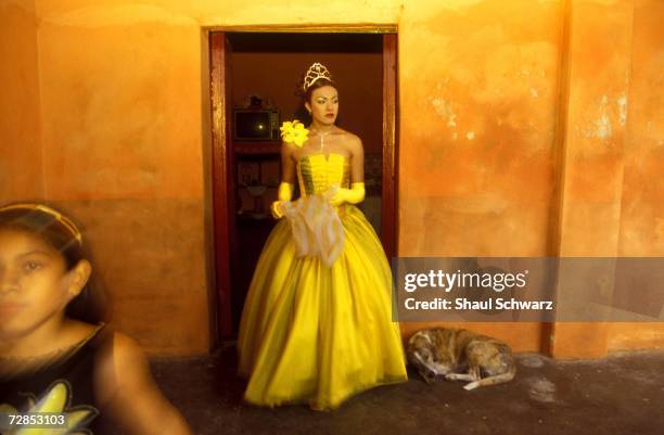 Queen America' walks out of her room after finishing her preparations for the vela de la Santa Cruz del Cielo in Juchitan, Mexico, October 16, 2002....