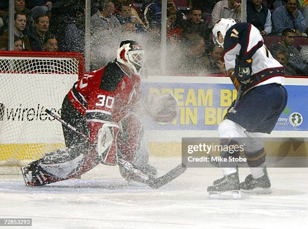 Goaltender Martin Broduer of the New Jersey Devils has ice kicked up into his face by J.P. Vigier of the Atlanta Thrashers on December 19, 2006 at...