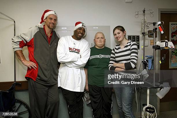 Assistant coach Larry Krystkowiak and Michael Redd of the Milwaukee Bucks pose for a photograph with a patient and his sister on December 19, 2006 at...