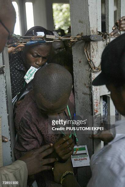 Party delegates squeeze through a narrow passage created by security operatives in Tafawa Balewa Square in Lagos 20 December 2006, where Nigerian...