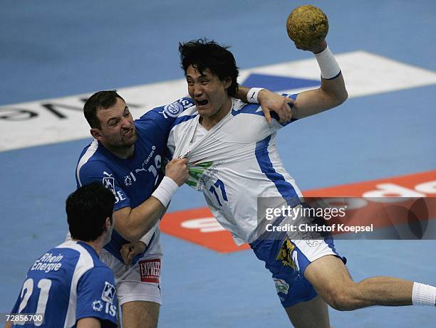 Sverre Jakobsson of Gummersbach pushes Kyung-Shin Yoon of Hamburg during the 1. Handball-Bundesliga match between VFL Gummersbach and HSV Handball at...