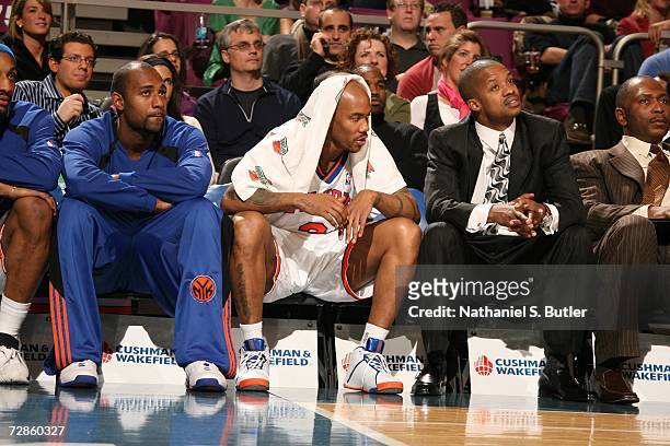 Stephon Marbury of the New York Knicks sits on the bench between Mardy Collins and Steve Francis during the NBA game against the Milwaukee Bucks on...