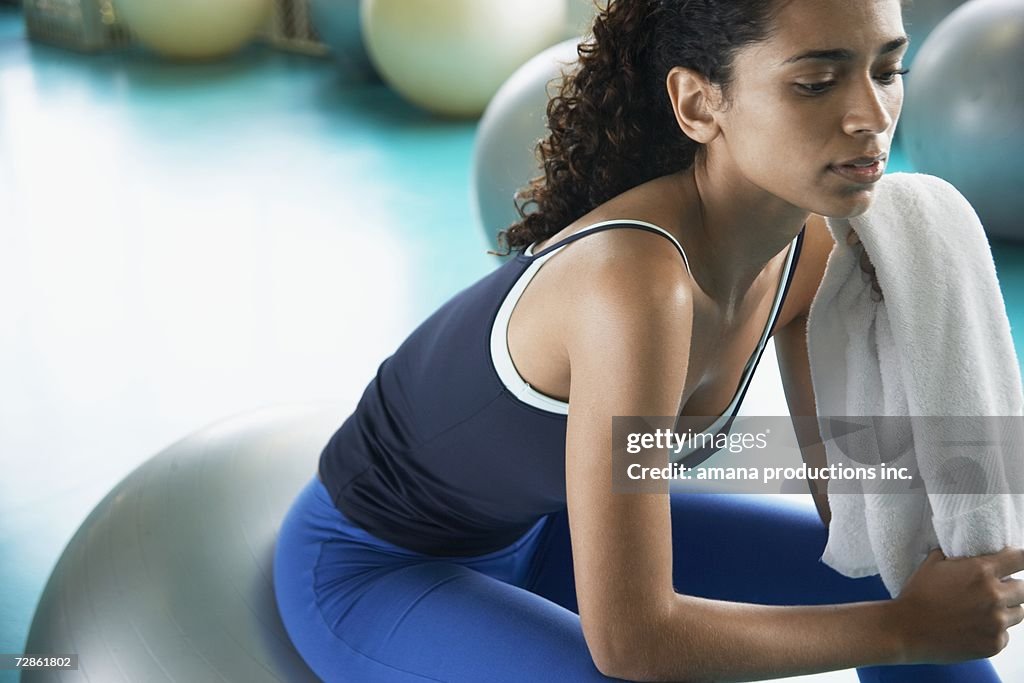 Young woman sitting on Swiss ball