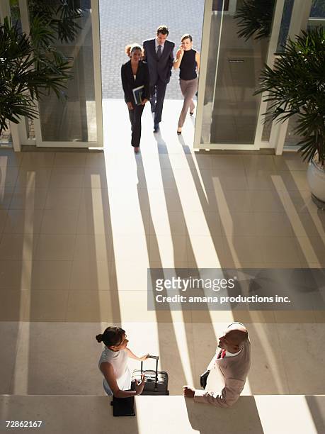 businesspeople meeting in entrance hall (high angle view) - black man high 5 stockfoto's en -beelden