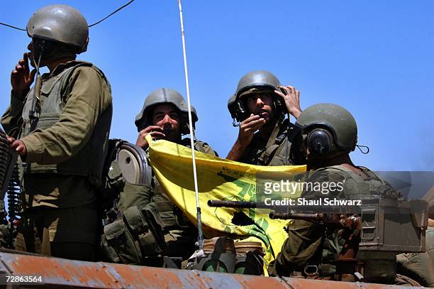 Israeli soldiers shows a Hezbollah flag as they come back from action against Hezbollah guerillas in south Lebanon July 25, 2006 on the...