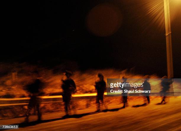 Israeli soldier walk near the Lebanon border as they cross over to take action against Hezbollah in the south of Lebanon July 23, 2006.
