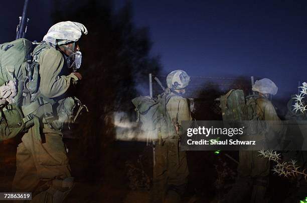 Israeli soldier walk near the Lebanon border as they cross over to take action against Hezbollah in the south of Lebanon July 23, 2006.