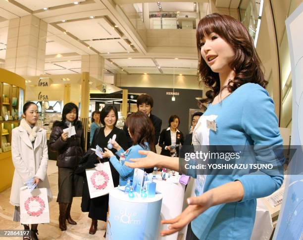 Promotional women along with a 165cm tall humanoid robot "Actroid" introduce French Azzaro perfumes at a Chiristmas gift promotion at Takashimaya...