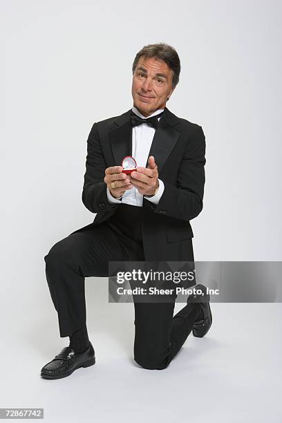 mature man holding engagement ring, smiling, portrait - man proposing indoor stock pictures, royalty-free photos & images