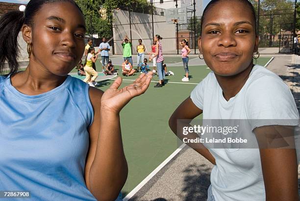 teenage girls (14-15) smiling, group of girls playing skipping in background - court notice bildbanksfoton och bilder