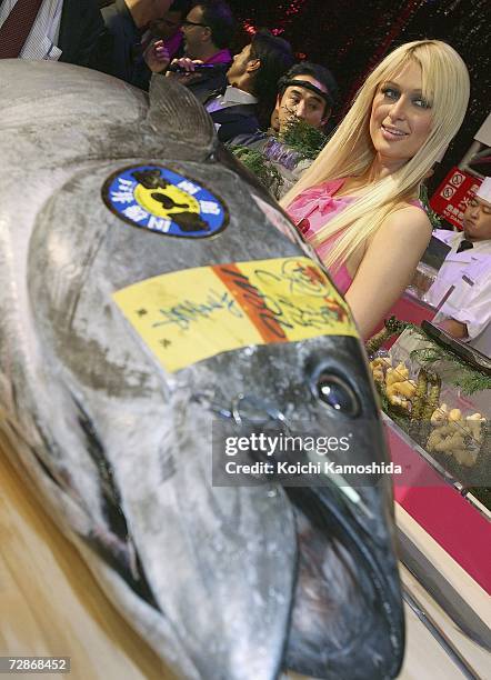 Paris Hilton poses in front of a big tuna fish during a mobile phone event at the Tsukiji Hongwanji Temple on December 22, 2006 in Tokyo, Japan.