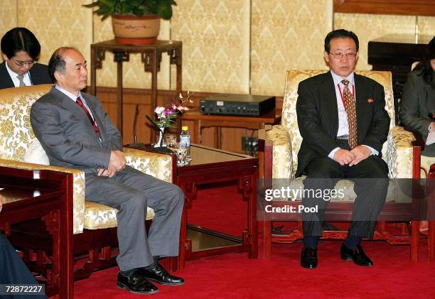 Japanese chief envoy Kenichiro Sasae sits next to North Korea's negotiator Kim Kye Gwan as they listen to a speech by Chinese State Councillor Tang...