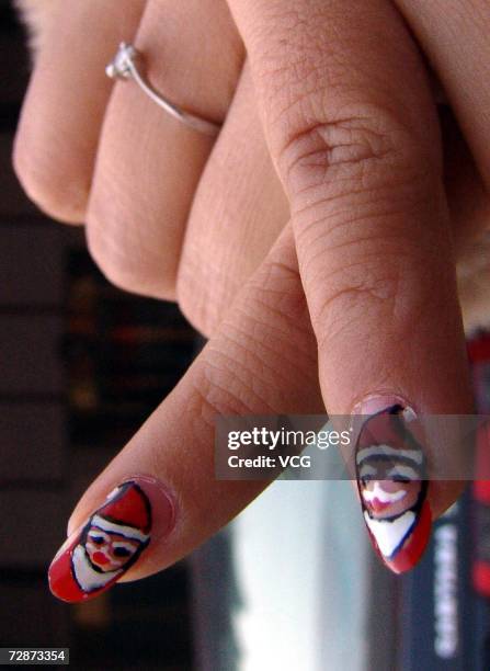 Girl shows her Santa Claus beauty nail for Christmas on December 22, 2006 in Zhengzhou, Henan Province, China. While Christmas Day is not a public...