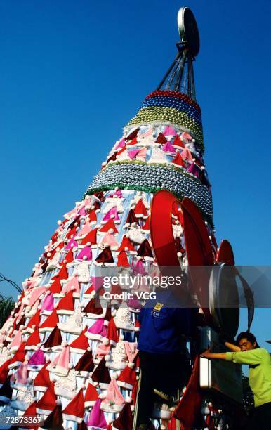 Christmas tree made of a lot of Santa Claus hats stands decorated for upcoming Christmas outside of the shopping center on December 22, 2006 in...