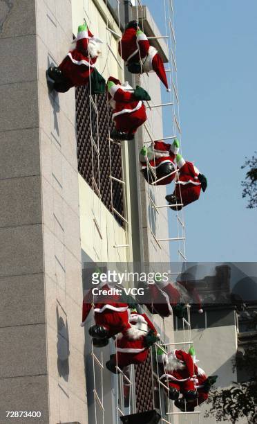 Several Santa Claus decorations hang on the wall to mark upcoming Christmas on December 22, 2006 in Yangzhou, China. While Christmas Day is not a...
