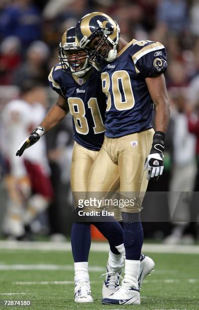 Torry Holt of the St. Louis Rams congratulates teammate Isaac Bruce after Bruce made a catch to set up a touchdown in the second quarter against the...