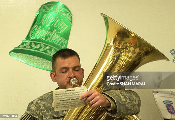 Soldier plays Christmas carols at a Christmas lunch at Bagram Air Base, some 50 kms north of Kabul, 25 December 2006. Many soldiers were able to call...