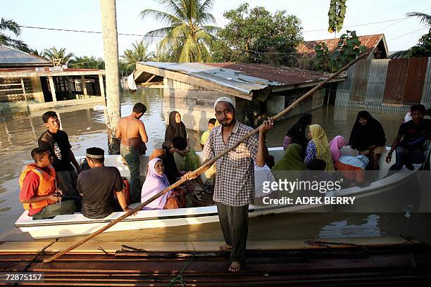 Acehnese people use a boat as they leave an Islamic Boarding school at Arakudo subdistrict in Langsa, East Aceh, 25 December 2006. Two years after...