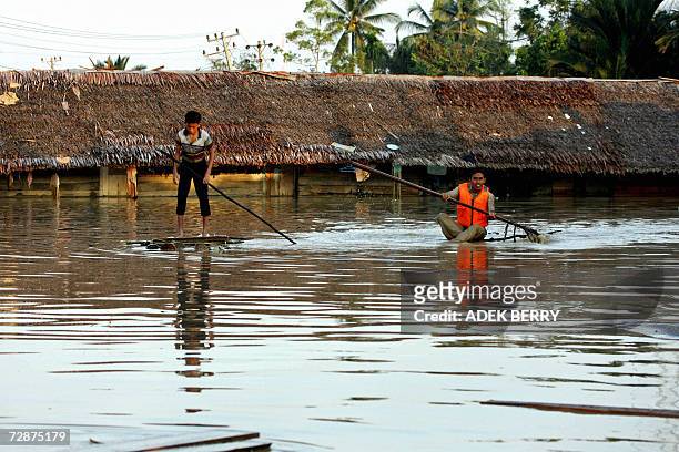 Two young men use makeshift rafts as they check the surroundings of an Islamic Boarding School at Arakudo subdistrict in Langsa, East Aceh, 25...