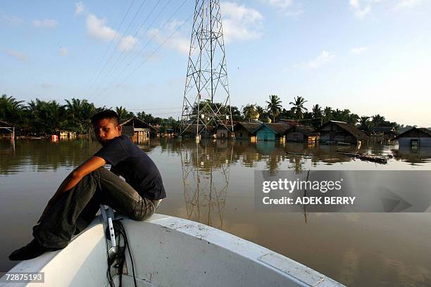 Boat man sits on a boat as he transfers people across flood water at Arakudo subdistrict in Langsa, East Aceh, 25 December 2006. Two years after the...