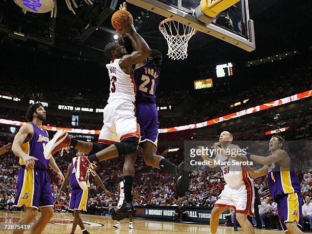 Guard Dwyane Wade of the Miami Heat is defended by forward Ronnie Turiaf, guard Sasha Vujacic and forward Luke Walton of the Los Angeles Lakers as...
