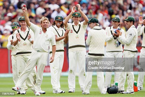 Shane Warne of Australia celebrates his 700th wicket with his team-mates after bowling out Andrew Strauss of England during day one of the fourth...