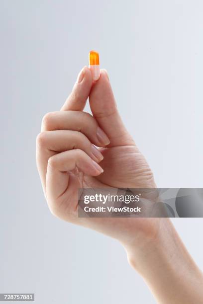 hand holding pills - finger tablet stock pictures, royalty-free photos & images